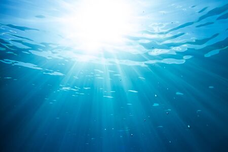 sun and sunbeams underwater shining through the surfaceの写真素材