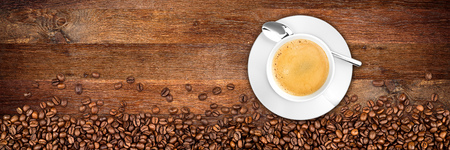coffee cup and beans on wide rustic oak backgroundの写真素材