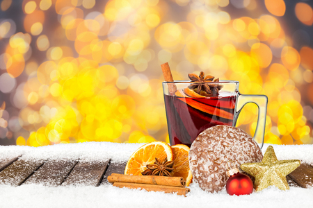 hot spiced mulled wine on wooden snowy planks in front of bright golden bokeh lights  backgroundの写真素材