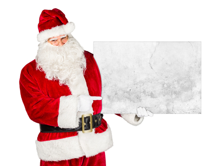 traditional classic red white santa claus pointing with his finger on concrete stone billboard in his other hand isolated on white backgroundの写真素材