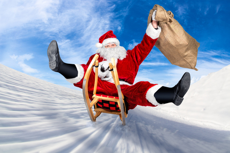 crazy santa claus on his sleigh hilarious fast funny crazy xmas christmas gift present delivery blue sky backgroundの写真素材