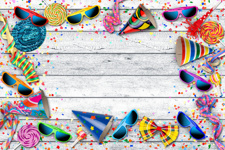 party carnival birthday celebration background with colorful streamer sunglasses confetti hat lolly pop on white wooden tableの写真素材