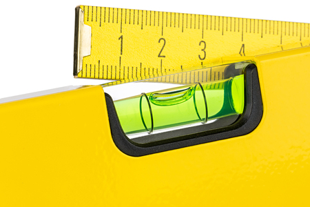 yellow spirit level and folding rule isolated on white backgroundの写真素材