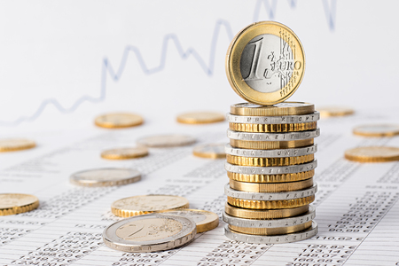 finance business accounting stock background with stack of euro coins on data sheetの写真素材