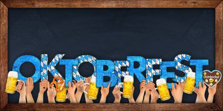 people hands holding up wooden oktoberfest letter lettering with beer mugs german pretzel on...