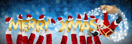 Merry christmas xmas greeting crazy funny santa claus on sleigh and costume arms holding up golden letters on blue snow panorama backgroundの写真素材