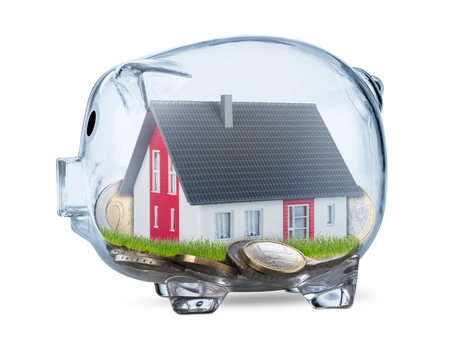 transparent piggy bank with savings euro coins and model of detached house inside isolated on white background real estate business financial conceptの写真素材