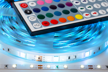 Bright RGB LED stripn light with remote control electronics energy saving decoration technology in front of white backgroundの写真素材