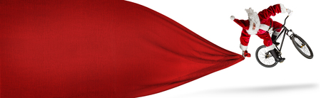 crazy santa claus jump on dirt mountain bike with big huge red bag copy space isolated white banner backgroundの写真素材