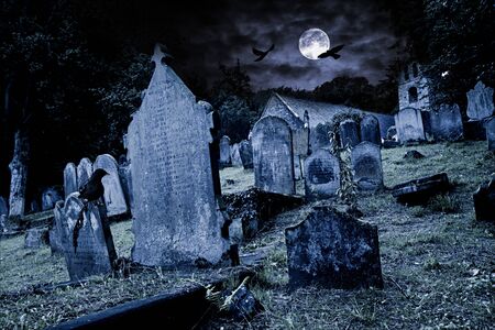old graveyard with ancient tombstones grave stone and old church in front of full moon black raven dark night spooky horror backgroundの販売画像