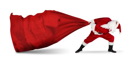 classic traditional crazy funny santa claus on exhausting delivery service. towing huge giant big red bag with christmas gift present  isolated on white backgroundの写真素材