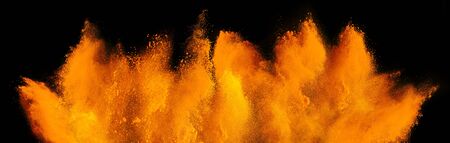 orange red holi paint color powder explosion isolated on dark black background. industry beautiful party festival conceptの写真素材