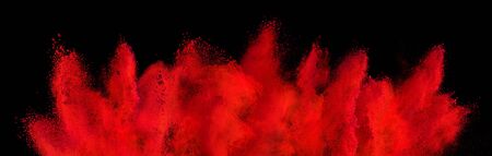 red holi paint color powder explosion isolated on dark black background. industry beautiful party festival conceptの写真素材