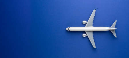 Top view of white commercial passenger airline airplane jet on blue background with copy space. Transportation tourism travel aviation and business concept.の写真素材
