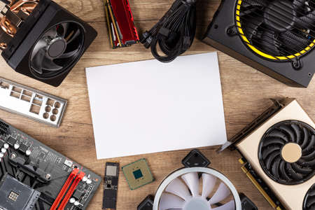 modern desktop computer hardware components on wood desk table with blank copy space paper background. Circle shaped pc parts like cpu motherboard graphics card and ssd wood technology concept.の写真素材