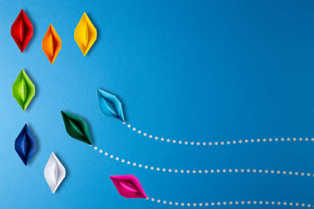 Colorful origami paper boat ships joining the team. Business unity team teamwork and competition...