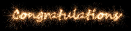 golden bright Congratulations sparkler letter lettering isolated on dark black background....
