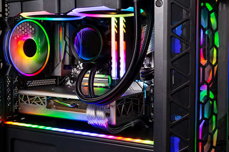 Inside view of black high end custom colorful illuminated bright rainbow RGB LED gaming pc. Computer power hardware and technology concept backgroundの写真素材