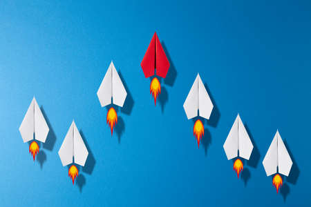Top view of paper plane race. white paper planes follow the red leader origami plane. Abstract business leadership competition race concept background.の写真素材
