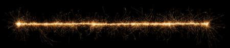 golden bright sparkler wide panorama tracer fuse line isolated on dark black background. anniversary, pyrotechnics, wedding and happy birthday celebration party conceptの写真素材