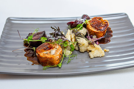 Eating out at an expensive place prepared by a professional chef. A portion of food served on a gray plate.の写真素材