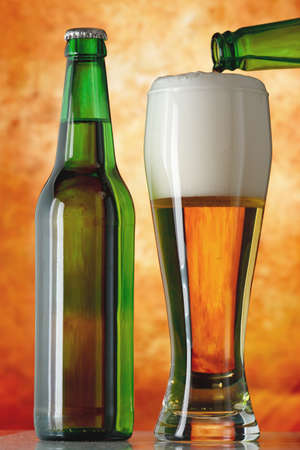 Bottle glass of beer on a yellow backgroundの写真素材