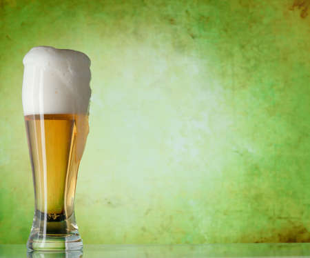 Glass of beer on a green backgroundの写真素材