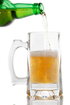 Beer is pouring into glass on white background の写真素材
