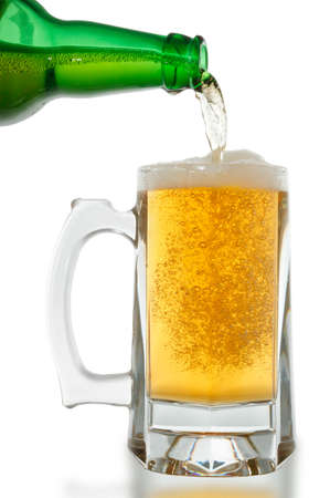 Beer is pouring into glass on white background の写真素材