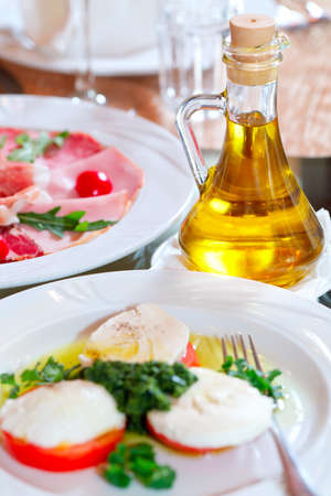 Bottle of sauce, sliced ??mozzarella and tomatoesの写真素材