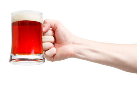 Closeup of a male hand holding up a glass of beer over a white backgroundの写真素材