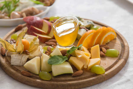 Still-life cheese platter with nuts and grapesの写真素材