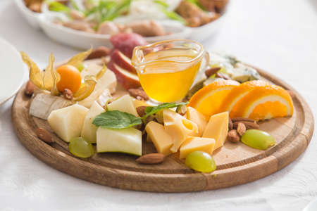 Still-life cheese platter with nuts and grapesの写真素材