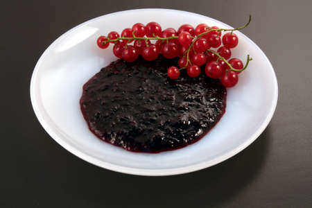 Fresh Red  currant and jam served on white plateの写真素材