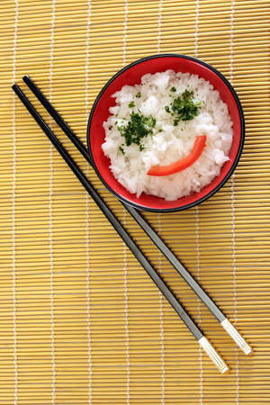 Chinese food in a black plate and sticksの写真素材