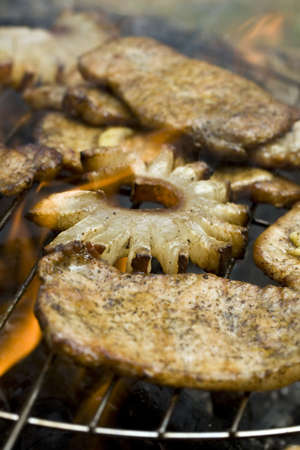 thick seasoned pork chops cooking on the grill in flames の写真素材