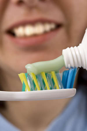 toothbrush and green bio toothpaste, in background a woman face