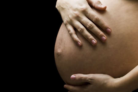 Image of pregnant woman touching her belly with hands 
