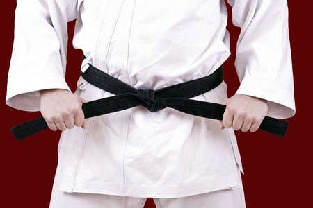 Martial arts athlete tying the knot to his black beltの写真素材