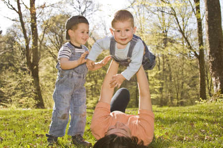 family lifestyle portrait of a mom with their two kids having fun outdoors の写真素材