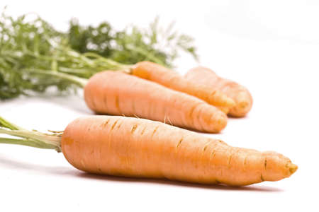 fresh bio carrots with green leaves isolated on white background の写真素材