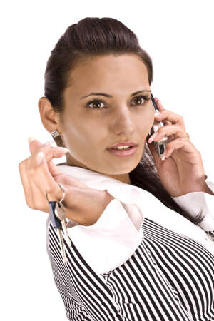 woman showing key in her hand and talking whit cellphone, focus on the eyeの写真素材