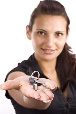 woman showing key in her palms, focus on the keyの写真素材