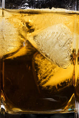 Whiskey in glass with ice cubesの写真素材