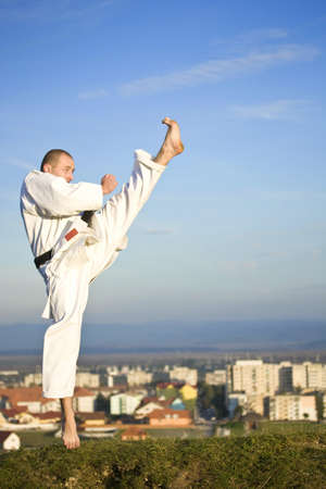 Young adult men practicing Karate outdoor, city in background
