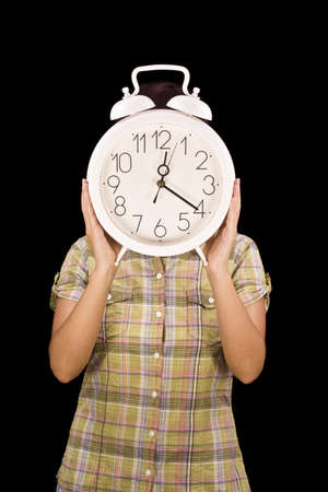 Woman holding clock, in black backgroundの写真素材