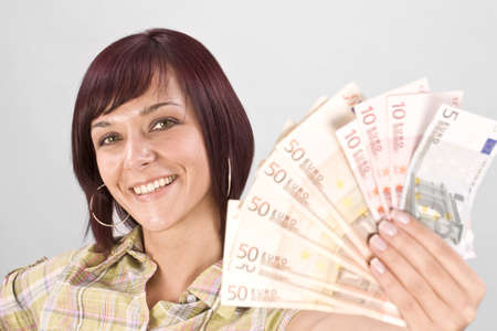 Woman holding money, in gray backgroundの写真素材