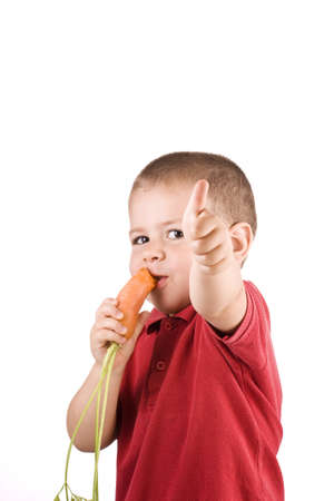 Boy eating fresh carrot isolated on white background の写真素材