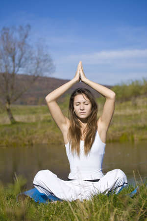 Slender young woman doing yoga exercise outdoors. の写真素材