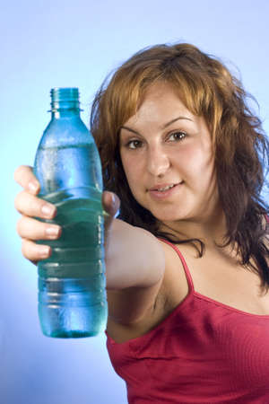 beautiful woman with bottle of water over blueの写真素材